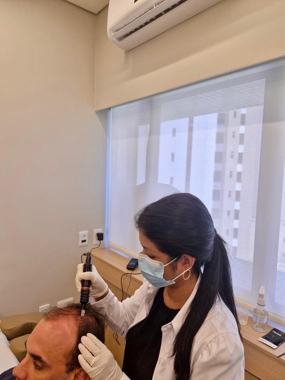 Dra. Fernanda Soares realizando procedimento capilar em ambiente clínico